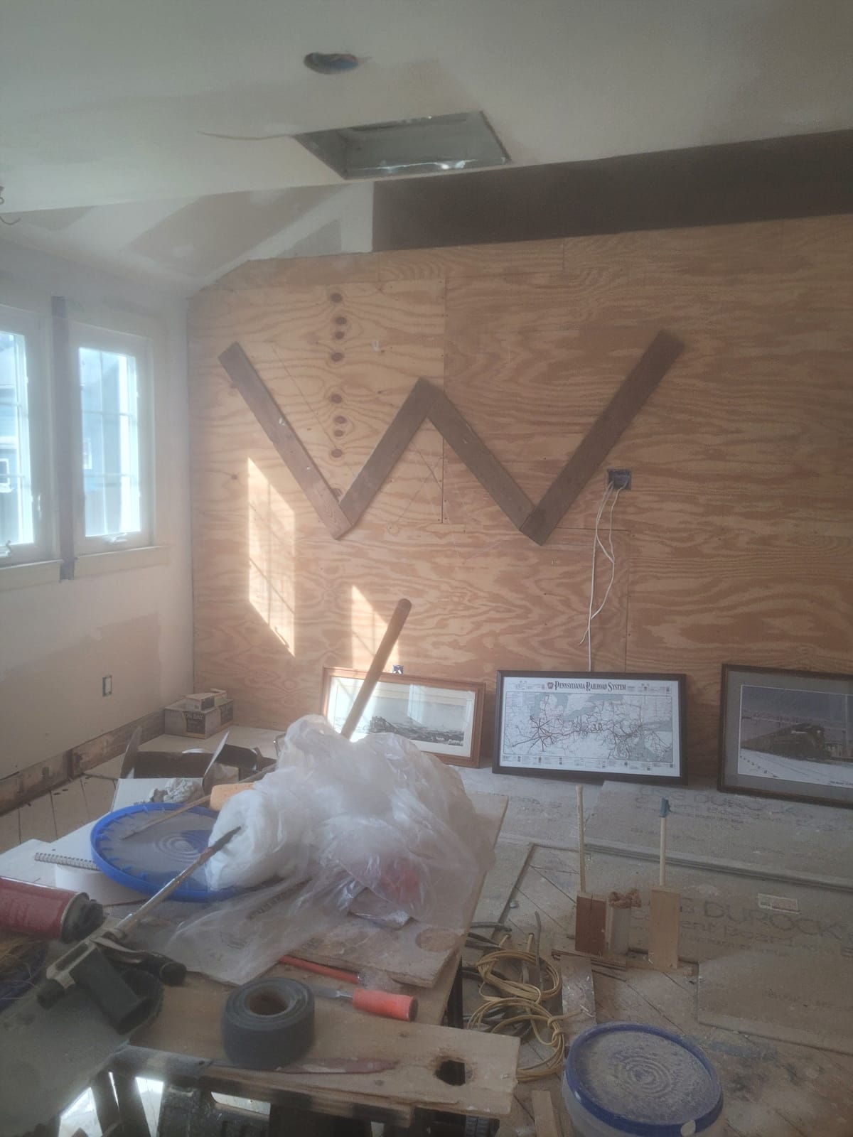 Another construction-phase view of the same space, with protective sheeting and unfinished walls.